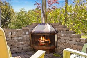 a fireplace in a brick wall with two chairs at Bennett Valley Eden in Santa Rosa
