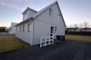 a white building with a porch and a yard at Keflavik Heart in Keflavík