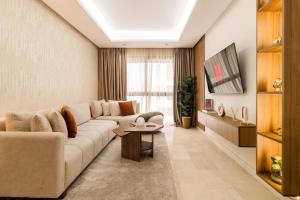 a living room with a couch and a table at Appartement Uptown CFC - Piscine - Gym - Parking Gratuit in Casablanca