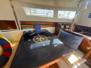 an inside view of a boat with a table with a compass on it at Beach Cosy Boat in Oeiras +16 photos