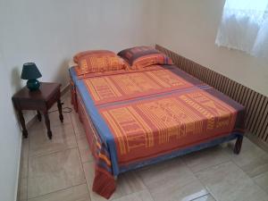 a bedroom with a bed and a night stand and a table at Villa Greg in Bouillante