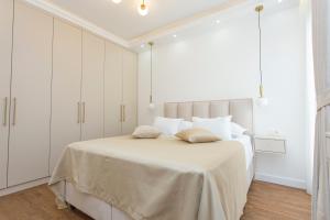 a white bedroom with a large bed with white cabinets at Apartment Harmonia in Dobrota +27 photos