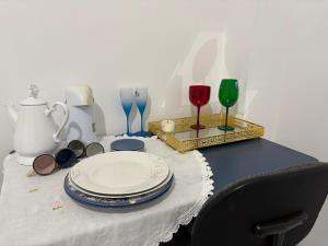 a table with plates and wine glasses on it at Studio suite casal in Teresina