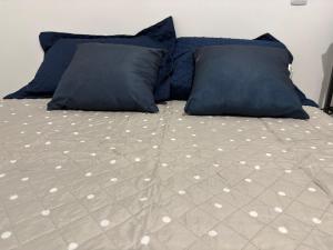 a bed with two blue pillows and a bedsheet at Studio suite casal in Teresina