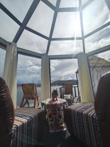 a room with a table and chairs and a large window at LAKE TITICACA LODGE in Puno