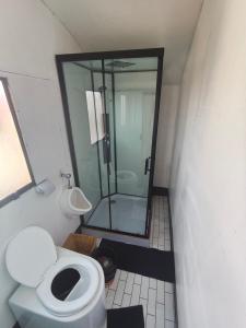 a bathroom with a toilet and a glass shower at LAKE TITICACA LODGE in Puno