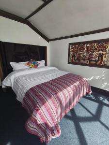 a bedroom with a bed with a striped blanket at LAKE TITICACA LODGE in Puno