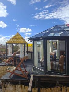 a house with a gazebo and a chair on a deck at LAKE TITICACA LODGE in Puno