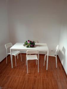 a white table with chairs and a vase of flowers on it at Holiday Home T3 to T6 on suite in Amparo II +8 photos