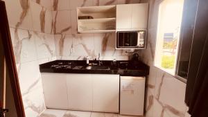 a small kitchen with a sink and a microwave at Loft da 14 in Soure