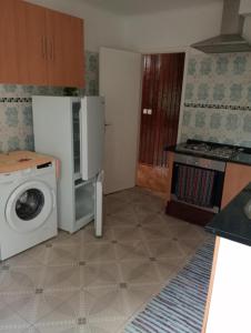 a kitchen with a microwave and a washing machine at Holiday Home T3 to T6 on suite in Amparo II