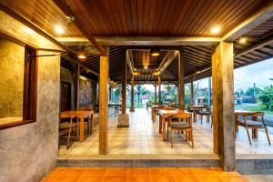 a dining room with wooden tables and chairs at Taru Sebatu Villa in Ubud