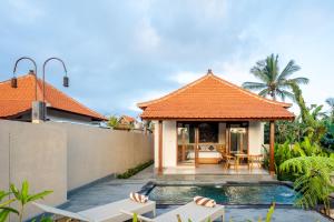 a villa with a swimming pool and a house at Taru Sebatu Villa in Ubud