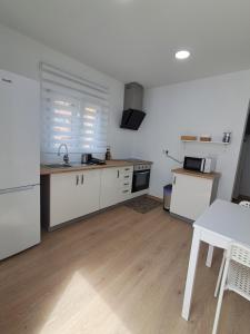 a kitchen with white cabinets and a sink and a table at Andrea's house in Charco del Pino