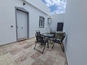a dining room with a table and chairs and a white wall at Andrea's house in Charco del Pino