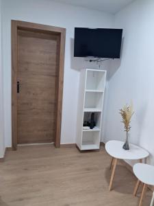 a room with a door and a table and a tv at Andrea's house in Charco del Pino