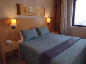 a hotel room with a bed and a window at MN Gotado Hotel Flat Guarulhos Aeroporto in Guarulhos