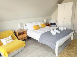 a bedroom with two beds and a chair at Gig Lodge Perfect Swanage Base in Swanage