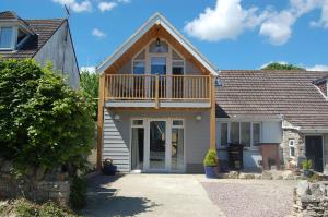 a house with a balcony on top of it at Gig Lodge Perfect Swanage Base in Swanage