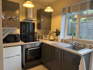 a kitchen with a sink and a microwave at Gig Lodge Perfect Swanage Base in Swanage