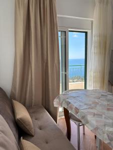 a living room with a table and a view of the ocean at HORIZONT Rooms in Lukovë +51 photos