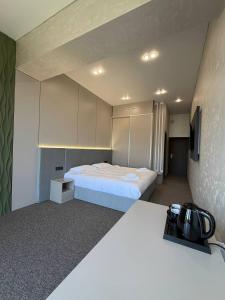 a small room with a bed and a tv at Ave Garden in Osh