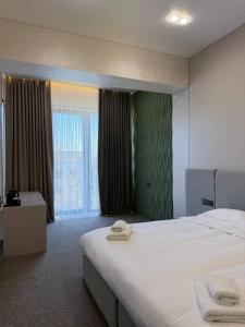 a hotel room with a bed and a large window at Ave Garden in Osh