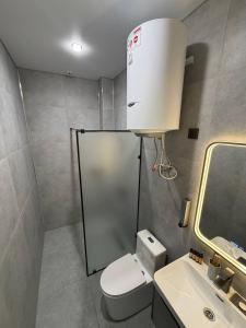 a small bathroom with a toilet and a sink at Ave Garden in Osh