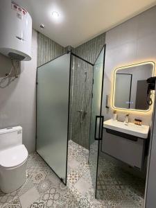 a bathroom with a shower and a toilet and a sink at Ave Garden in Osh