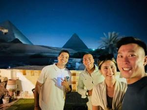 a group of people standing in front of the pyramids at Kemet Pyramids Room view in Cairo
