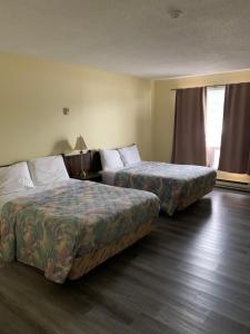a hotel room with two beds and a window at Spanish River Inn in Spanish +13 photos