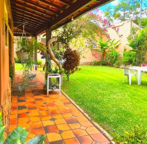 a garden with a patio and a grass yard at Suítes Colibri da Serra - Piscina & Conforto em Itaipava RJ in Itaipava +52 photos
