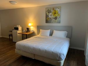 a bedroom with a bed and a desk with a microwave at Spanish River Inn in Spanish