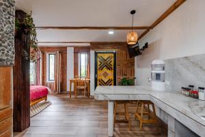 a kitchen with a counter and a table in a room at Watzara Wasi Studios en Cotacachi in Cotacachi