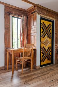 a dining room with a table and a chair and a window at Watzara Wasi Studios en Cotacachi in Cotacachi