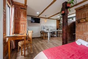 a bedroom with a bed and a desk and a table at Watzara Wasi Studios en Cotacachi in Cotacachi +35 photos