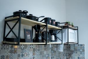 a kitchen shelf with pots and pans and a microwave at Studio confort com ar Centro de Niteroi in Niterói +40 photos