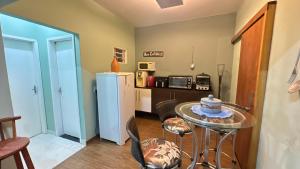 a small kitchen with a table and a refrigerator at Quarto com banheiro in Sao Jose do Rio Preto