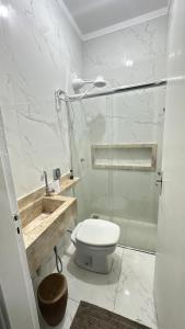a bathroom with a toilet and a glass shower at Quarto com banheiro in Sao Jose do Rio Preto