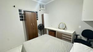 a room with a bed and a desk and a chair at Quarto com banheiro in Sao Jose do Rio Preto