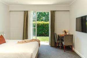 a bedroom with a bed and a table and a window at Punthill Narrabundah in Canberra +51 photos