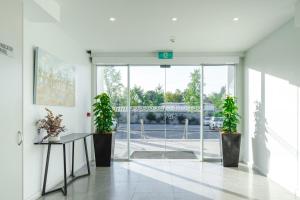 a hallway with two potted plants in a building at Punthill Narrabundah in Canberra