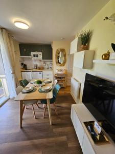 a kitchen and living room with a table and chairs at Le Trésor du Lac - Casteljaloux - Lac de Clarens - Appartement - Piscine - Parking - WIFI - Accès privée Plage - Golf - Casino - Terra Aventura - So Vélo in Casteljaloux +54 photos