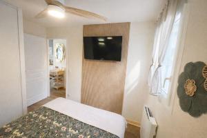 a bedroom with a bed and a flat screen tv at Le Trésor du Lac - Casteljaloux - Lac de Clarens - Appartement - Piscine - Parking - WIFI - Accès privée Plage - Golf - Casino - Terra Aventura - So Vélo in Casteljaloux