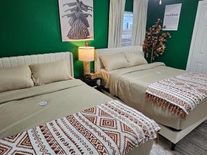 two beds in a room with green walls at 3BR Houston with Grill, Hot Tub and Game Room near NRG, Downtown and Hobby Airport in Houston