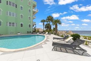 a swimming pool in front of a building and the ocean at Spacious Ocean View Apartments with Balcony in Blue Bay in Blue Bay