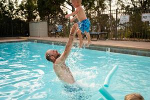 a man and a boy playing in a swimming pool at Durango RV Resort in Durango