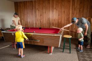 a man and two children playing with a pool table at Durango RV Resort in Durango