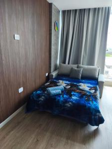 a bedroom with a bed with a blue blanket at San Pedro, Cristal INN in San Pedro +11 photos
