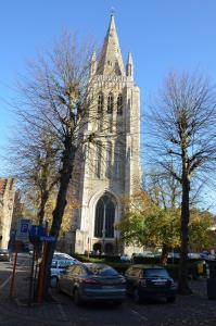 una iglesia con autos estacionados frente a ella en B&B Jacob20, en Ypres